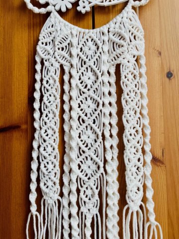 Weißes Makramee kombiniert mit einem hölzernen Blumenmuster