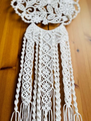Weißes Makramee kombiniert mit einem hölzernen Blumenmuster